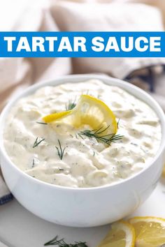 a close up of a bowl of tartar sauce with lemons on the side