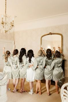 the bridesmaids are getting ready for their big day at the wedding venue in front of the mirror