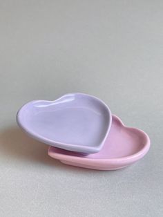 two heart shaped dishes sitting side by side on top of each other in pastel colors