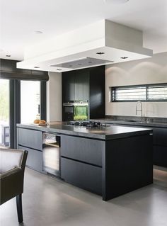 a modern kitchen with black cabinets and stainless steel appliances