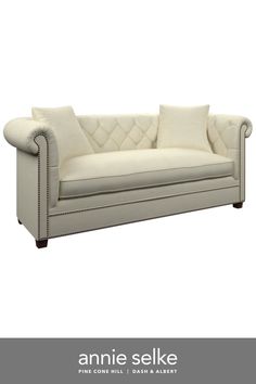 an image of a couch that is white and has some pillows on top of it