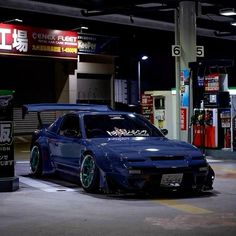 a blue car parked in front of a gas station