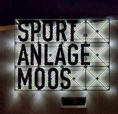 a neon sign that says sport analge moos on the side of a building