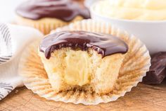 a chocolate covered cupcake sitting on top of a wooden cutting board