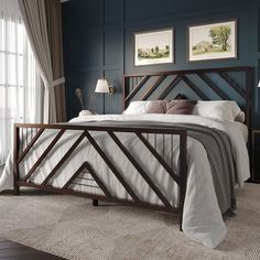 a bedroom with blue walls and white bedding, two pictures on the wall above the bed