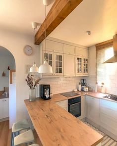 a kitchen with white cabinets and wooden counter tops, along with a breakfast nook