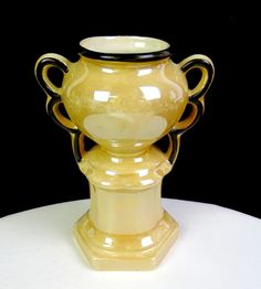 a yellow vase sitting on top of a white table