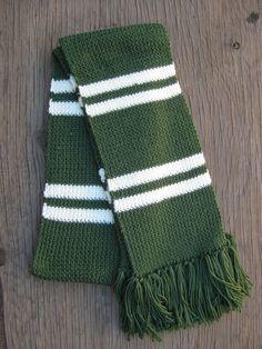 two green and white knitted scarves laying on top of each other