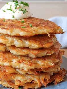 a stack of pancakes topped with whipped cream and chives