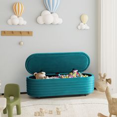 a toy storage box filled with toys in a child's playroom, including balloons and hot air balloons on the wall