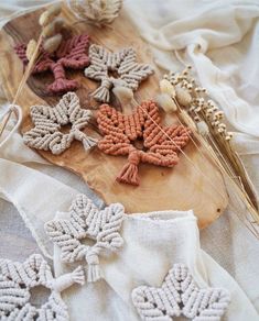 crocheted snowflakes are displayed on a wooden cutting board with wheat stalks