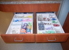 two drawers are open on the counter in front of a mirror with buttons and other items