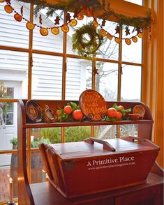 a trunk is sitting in front of a window with decorations on the windowsills