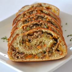 slices of bread filled with meat and vegetables on a white plate