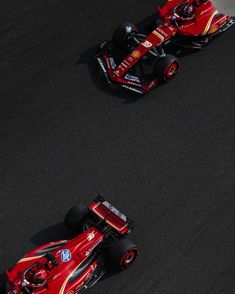 two red race cars driving on a track