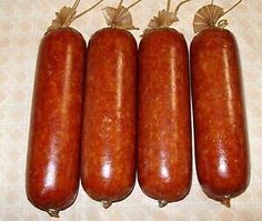 four hotdogs are lined up on a table with string wrapped around the edges