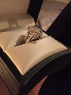 an engagement ring in a box with its shadow on it