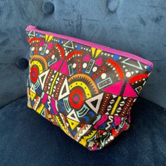 a colorful clutch bag sitting on top of a blue couch