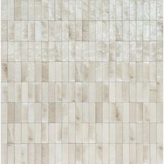 a white tile wall with different shades of beige