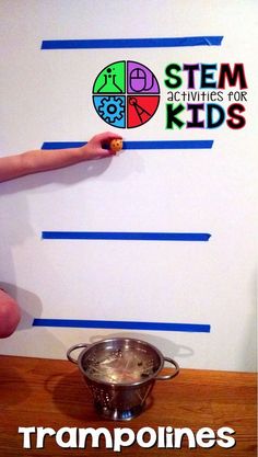 a young boy is drawing on the wall with blue tape and pointing it at something