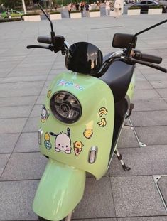 a green scooter with stickers on the front