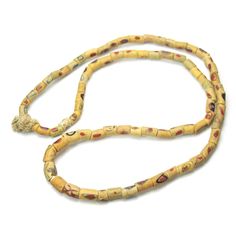 a long yellow beaded necklace on a white background