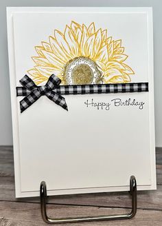 a card with a sunflower on it and a black and white ribbon around the edge