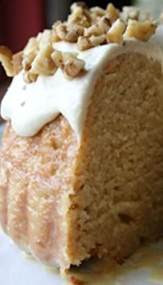 a piece of cake with white frosting and nuts on top