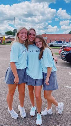 three girls are standing together in the parking lot and hugging each other with their arms around one another