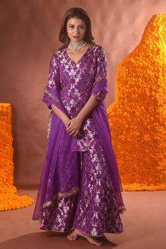 Purple banarasi silk kurta with floral pattern. Comes with sharara and a dupatta.
Components: 3
Type Of Work: Floral
Neckline: V Neck
Sleeve Type: Three quarter
Fabric: Banarasi silk
Color: Purple
Other Details: 
Note: Necklace worn by the model is not for sale.
Occasion: Mehendi and Haldi - Aza Fashions Unstitched Banarasi Silk Sharara With Dupatta, Semi-stitched Meenakari Sharara For Wedding, Tissue Silk Meenakari Dupatta For Eid, Traditional Purple Sharara For Festive Occasions, Purple Meenakari Traditional Wear For Eid, Traditional Drape Sharara In Banarasi Silk With Sheer Dupatta, Traditional Drape Sharara With Sheer Dupatta In Banarasi Silk, Unstitched Meenakari Tissue Silk Traditional Wear, Purple Banarasi Silk Sharara With Dupatta