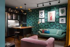 a living room filled with furniture next to a kitchen and dining room table in front of a green wall