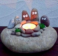 some rocks are sitting on top of a table with a lit candle in the middle