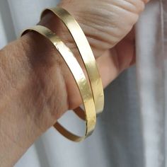 Gold bangle bracelet, lightly hammered bracelet, minimalist bracelet, basic bangle, gold stacking bracelets, simple gold bracelets, simple bangle A minimalist, gold bangle created from a narrow stripe of brass, which was later soldered, lightly hammered and plated with nickel free 14k gold. The bangle can be worn separately or stacked together with a similar or different bangles in my shop. This hammered bracelet is a perfect gift for women. Can be ordered lightly hammered or plain, with no text Minimalist Hammered Bangle For Everyday, Minimalist Everyday Hammered Bangle, Everyday Minimalist Hammered Bangle, Everyday Gold Hammered Bangle, Minimalist Hammered Bracelet Bangle, Minimalist Hammered Bangle Bracelet, Hammered Minimalist Bangle, Minimalist Hammered Gold Bracelets, Bracelets Simple