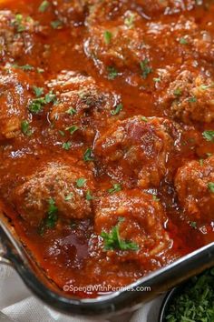 meatballs with tomato sauce and parsley in a casserole dish, ready to be eaten