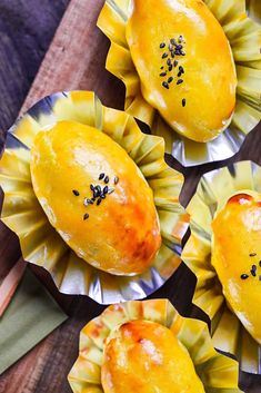 four lemons with black seeds on them sitting in tin foil cups, ready to be eaten