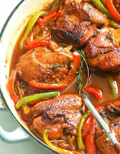 a pan filled with chicken and peppers on top of a table