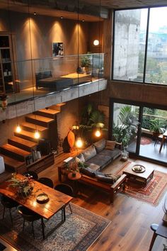 a living room filled with furniture and lots of windows next to a stair case that leads up to the second floor