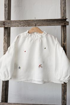 Exclusive meadow parachute tunic shirt with long puff sleeves and ruffled neckline is made of 100% soft medium weight linen.  Details: - Choose size in the drop down menu - Colour: White - Composition: 100% Oeko-Tex certified linen - Embroidered hedgehog, ladybug, blueberry, leaf, wild strawberry, clover & bee (front and back) - Ruffled sleeves - Ruffled neckline  - Medium weight linen - Linen care: machine wash gentle; tumble dry low, ironing optional - The price is for one tunic, other picture Spring Embroidered Long Sleeve Top With Ruffles, White Peasant Top With Smocked Cuffs And Long Sleeves, White Long Sleeve Peasant Top With Smocked Cuffs, White Long Sleeve Blouse With Smocked Cuffs, Cotton Tops With Balloon Sleeves And Smocked Cuffs, White Balloon Sleeve Top With Smocked Cuffs, White Balloon Sleeve Tops With Smocked Cuffs, Embroidered Spring Tops With Ruffled Collar, Fall Smock Top With Balloon Sleeves