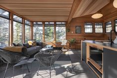 a living room filled with furniture and lots of glass windows next to a counter top