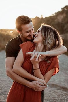 a man and woman embracing each other on the beach