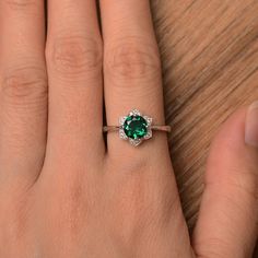 It is lab emerald ring, the main stone is about 7mm*7mm, round cut, weight about 1.3 carats. The basic metal is sterling silver and plated with rhodium. To change the metal to a solid gold (white/rose) or platinum is also available, please ask for a quotation if you want. You can also go to my shop Home for more elegant rings: https://www.etsy.com/shop/godjewelry?ref=hdr_shop_menu Lab emerald is May birthstone. More lab emerald rings: https://www.etsy.com/shop/godjewelry?ref=seller-platform-mcna Promise Ring Halo With Prong Setting For May Birthstone, Promise Ring With Prong Setting For May Birthstone, Green Emerald Halo Ring For Promise, Green Emerald-cut Halo Ring For Promise, Green Emerald Ring With Halo Design For Promise, May Birthstone Emerald Ring With Halo Design, Emerald Ring With Halo Design For Promise, Round Emerald Ring With Halo Setting For Promise, Green Round Cut Emerald Ring For Proposal