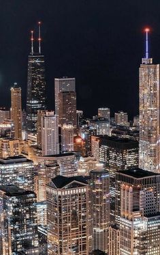 an aerial view of a city at night with skyscrapers lit up in the background