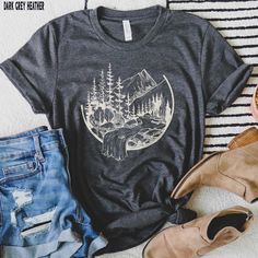 Our Mountains Waterfall graphic tee is perfect for those hiking the mountains or wishing they were! Looking for additional outdoor apparel? Check these out: https://www.etsy.com/shop/TheGraphicPeach?ref=seller-platform-mcnav§ion_id=31675954 Our shop uses direct-to-garment printing to make our products. The design ink is sprayed on, then allowed to soak into the fibers of the garment. This process yields fine quality prints and a smooth finish on the garment. BELLA + CANVAS T SHIRT The Bella + Ca Gray Crew Neck T-shirt For Outdoor Activities, Gray Graphic Print Top For Outdoor Activities, Crew Neck Hiking Shirt With Letter Print, Black Screen Print Shirt For Outdoor, Hiking Shirt With Letter Print And Crew Neck, Outdoor Black Shirt With Screen Print, Graphic Tee Shirt With Letter Print For Outdoor Activities, Relaxed Fit Crew Neck Shirt For Outdoor Activities, Relaxed Fit Graphic Tee For Outdoor