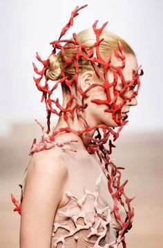 a woman's head with red corals on it