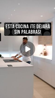 a man standing in front of a white counter top next to a kitchen area with an island