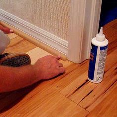 a man laying on the floor next to a bottle of glue