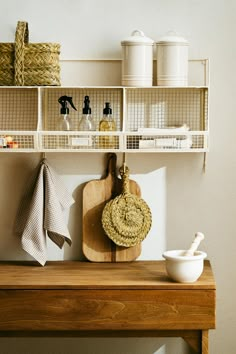 a wooden table topped with shelves filled with dishes and cooking utensils next to a cutting board