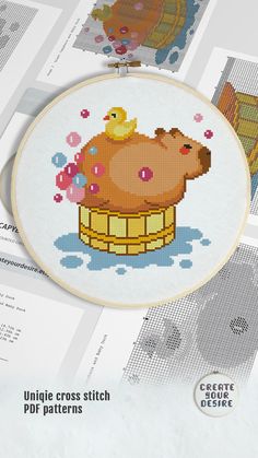 the cross stitch pattern has been designed to look like a bear in a bathtub