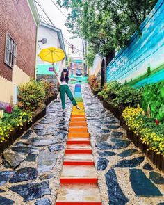 a woman holding an umbrella walking down a set of steps