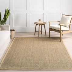 a living room with white walls and beige rugs on the floor next to a chair